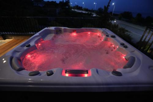 a hot tub with red lights in a backyard at night at Toka Hotel Restaurant in Pogradec
