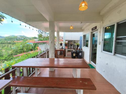 a porch with two wooden benches on a balcony at บ้านสุขอรุณ เขาค้อ Baan Sook A Roon KhaoKho in Khao Kho