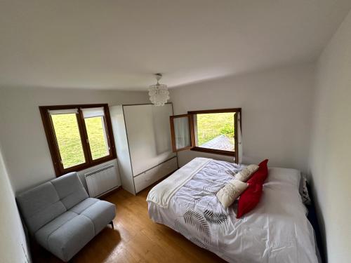 - une chambre avec un lit, une chaise et deux fenêtres dans l'établissement Peaceful Retreat Between Lake and Mountain Charming House Near Annecy and Aix-les-Bains, à Chainaz-les-Frasses