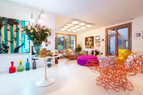 a living room with chairs and a table with a vase of flowers at Magic Forte in Forte dei Marmi