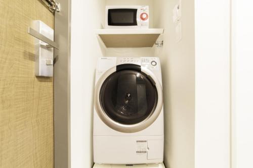 lavadora en una puerta con microondas en Tokyu Stay Ginza, en Tokio