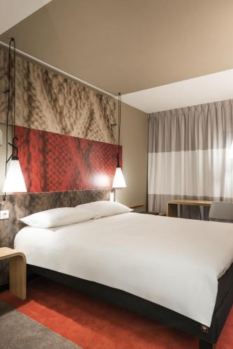 a bedroom with a large white bed in a room at ibis Saint-Omer Centre in Saint-Omer