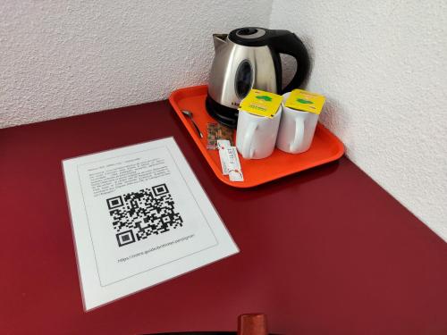 a tea kettle and two cups on an orange tray at Brit Hotel Porte d'Espagne in Perpignan