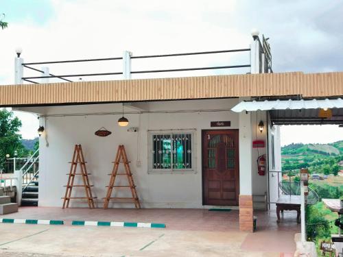 a building with a ladder and a door on it at บ้านสุขอรุณ เขาค้อ Baan Sook A Roon KhaoKho in Khao Kho