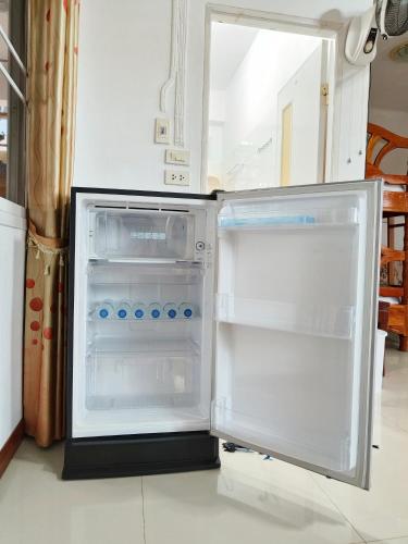 an empty refrigerator with its door open in a kitchen at บ้านสุขอรุณ เขาค้อ Baan Sook A Roon KhaoKho in Khao Kho