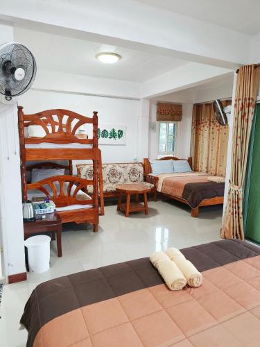 a bedroom with two beds and a bunk bed at บ้านสุขอรุณ เขาค้อ Baan Sook A Roon KhaoKho in Khao Kho