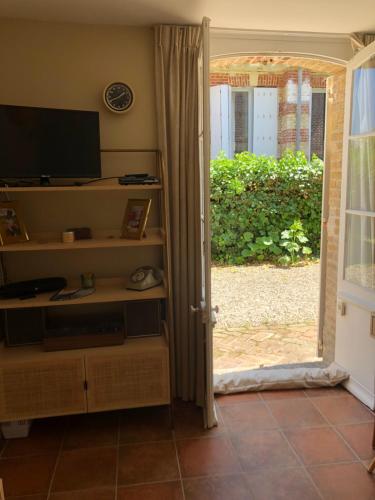 - un salon avec une porte s'ouvrant sur une cour dans l'établissement Le cottage de Gabriel Front de mer, à Villers-sur-Mer