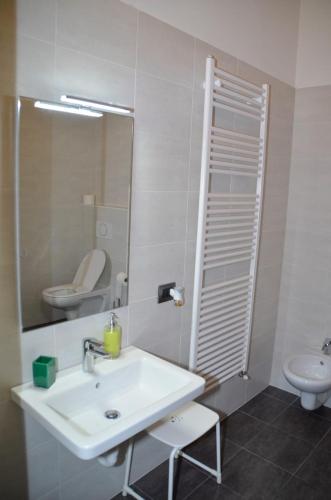 a bathroom with a sink and a toilet and a mirror at La Caigola in Ala