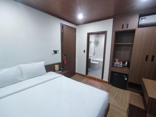 a bedroom with a white bed and a bathroom at GREENECO DA LAT HOTEL - Khách sạn Green Eco Đà Lạt in Da Lat