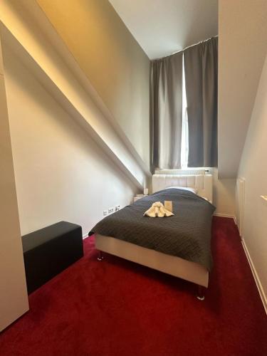 a bedroom with a bed with a window and red carpet at DATRI Petite Suite 4 in Vienna