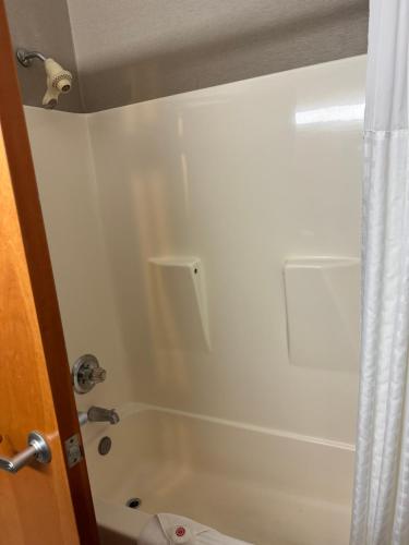a white bathroom with a tub and a shower at Comfort Inn Huntington near University area in Huntington