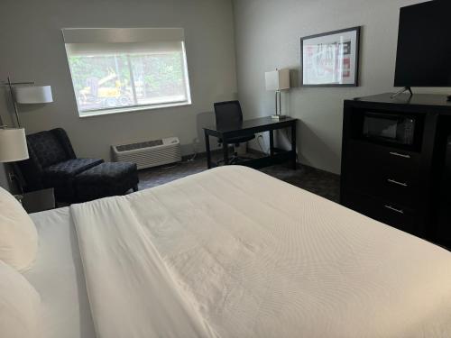 a hotel room with a white bed and a desk at Comfort Inn Huntington near University area in Huntington
