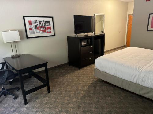 a hotel room with a bed and a desk and a television at Comfort Inn Huntington near University area in Huntington