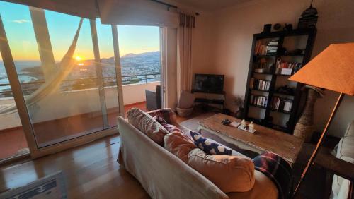 a living room with a couch and a large window at Murteiras Living in Funchal