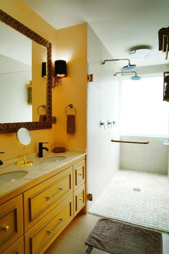 a bathroom with two sinks and a shower with a mirror at Minho Valley in Caminha