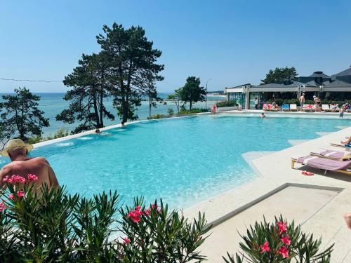 STEAUA DE MARE - Olimp Resort في أوليمب: شخص يجلس بجوار حمام سباحة كبير