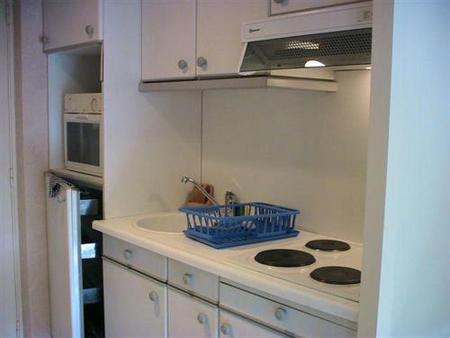 une petite cuisine avec un évier et une cuisinière dans l'établissement Gautier Jean, à Cannes