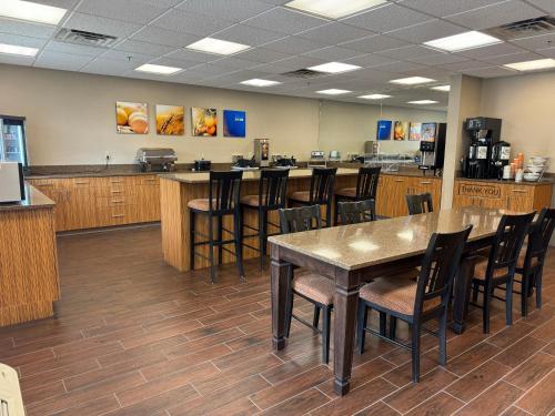 a restaurant with a table and chairs and a bar at Comfort Inn Huntington near University area in Huntington