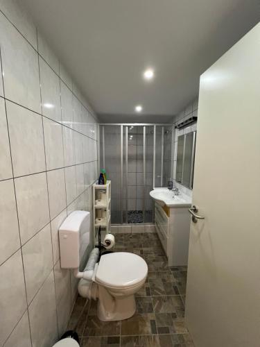 a bathroom with a white toilet and a sink at Zimmer in geteilter Ferienwohnung in Bremerhaven