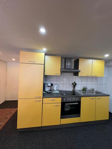 a kitchen with yellow cabinets and a stove at Zimmer in geteilter Ferienwohnung in Bremerhaven
