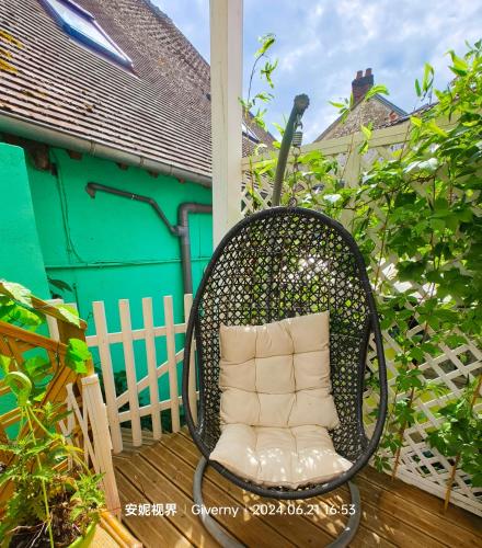 a wicker chair sitting on top of a deck at Le Coin des Artistes in Giverny