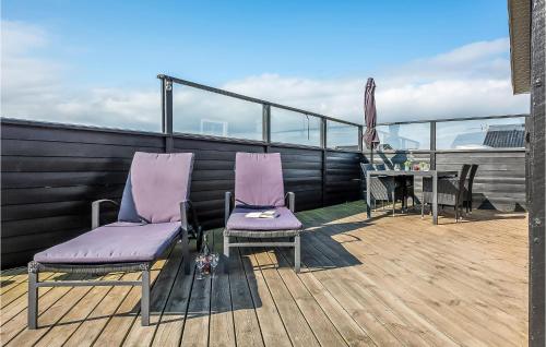 two purple chairs and a table on a balcony at Holiday Home Hvide Sande 24 in Bjerregård