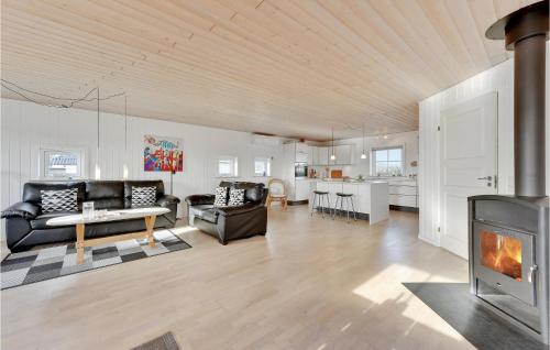 a living room with a couch and a fireplace at Holiday Home Hvide Sande 24 in Bjerregård