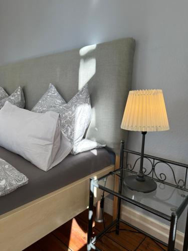 a bed with pillows and a lamp on a glass table at Altes Pastorat in Barmstedt
