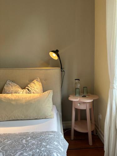 a bedroom with a bed with a lamp and a side table at Altes Pastorat in Barmstedt