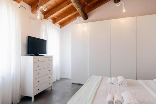 una camera con letto e TV su un comò di San Zen Che Ride a Verona