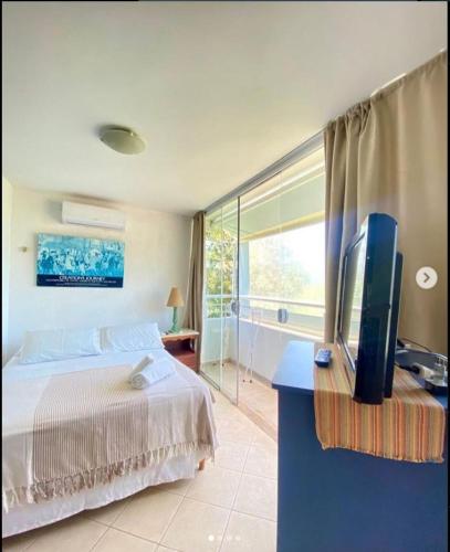 a bedroom with a bed and a television on a desk at GH Bizkaia in Florianópolis