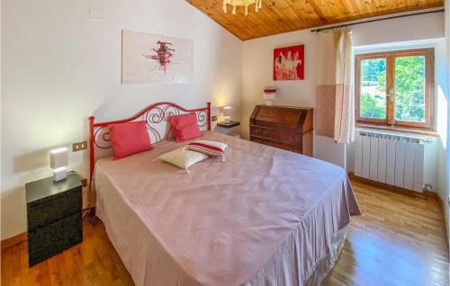 a bedroom with a large bed with pink pillows at Beautiful Home In Caprese Michelangelo in Caprese Michelangelo
