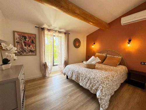 une chambre avec un lit et une grande fenêtre dans l'établissement Mas des Papillons en Provence, à Rasteau