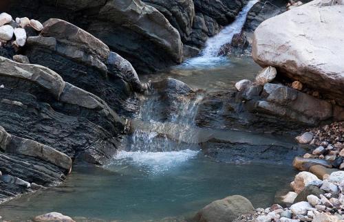a small waterfall in a rocky river with rocks at Agathi in Pramanta