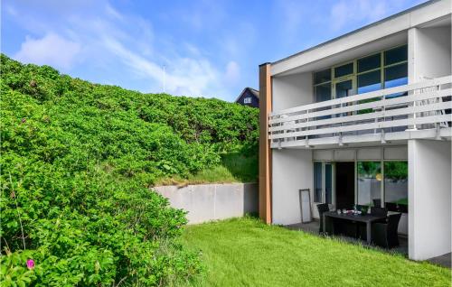 an exterior view of a white house with a hedge at Awesome Apartment In Ringkøbing in Ringkøbing