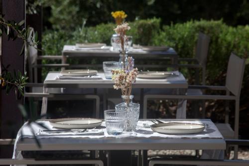 a table with plates and glasses and flowers on it at Casale Sterpeti in Magliano in Toscana