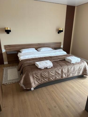 a bedroom with a bed with two towels on it at Guest House Zatyshnyi Dvir in Bukovel