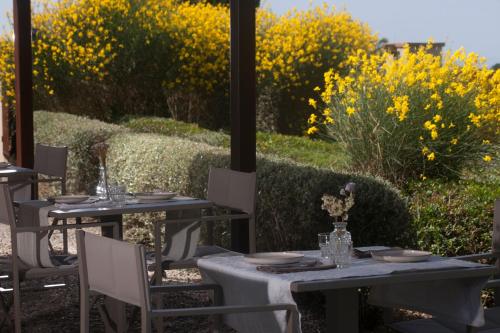 two tables and chairs with flowers on a patio at Casale Sterpeti in Magliano in Toscana