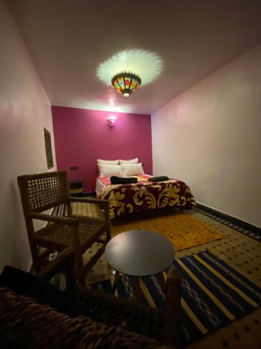 a room with a bed and a table and a lamp at Dar El Mizan Entier place in Fès