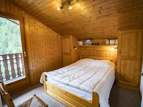 une chambre avec un lit dans une pièce en bois dans l'établissement Appartement Châtel 4 pièces, 6 pers. avec balcon, garage, wifi - FR-1-676-160, à Châtel