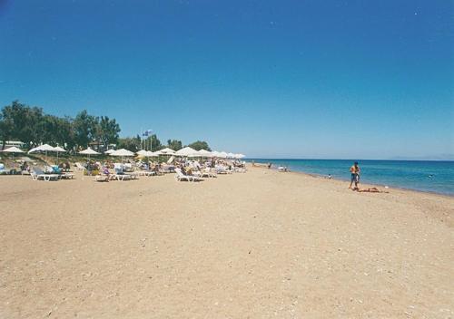 a group of people on a beach with umbrellas at Vaïana in Frangoulaíika