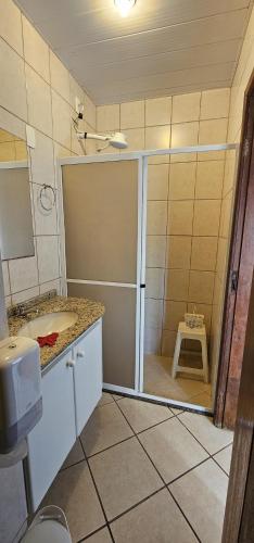 a bathroom with a shower with a sliding glass door at GH Bizkaia in Florianópolis
