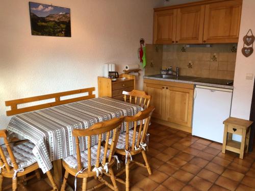une cuisine avec une table et des chaises et une table et un comptoir dans l'établissement Studio cosy à Châtel, 4 pers, balcon, proche remontées mécaniques et navettes, parking inclus - FR-1-676-188, à Châtel