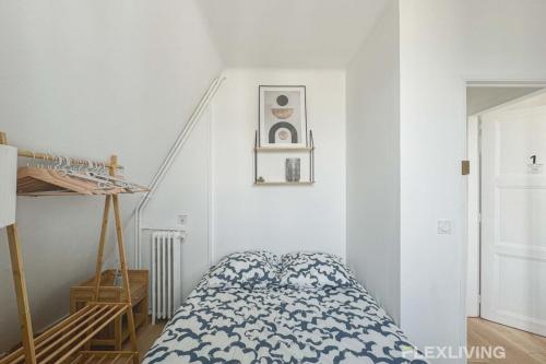 - une chambre blanche avec un lit et un escalier dans l'établissement Flexliving - room - Houel, à Paris