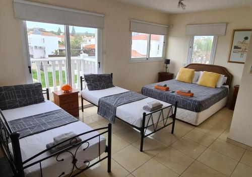 ein Wohnzimmer mit zwei Betten und einem Balkon in der Unterkunft Villa Julia in Ayia Napa