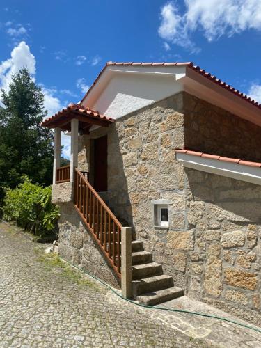 a stone building with a staircase and a porch at Quinta da Cavada - Casa da Tertúlia in Vouzela