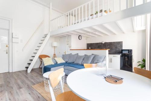 - un salon avec une table blanche et un canapé bleu dans l'établissement Magnifique appartement - République Beaux-Arts, à Lille