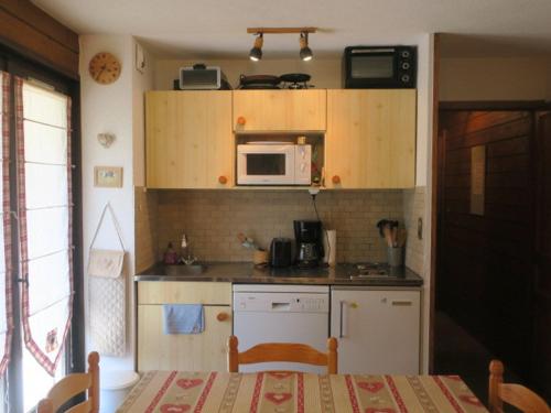 une petite cuisine avec une table et un micro-ondes dans l'établissement Studio cosy pour 4 personnes avec balcon, à 300m du télésiège de Barbossine à Châtel - FR-1-198-146, à Châtel