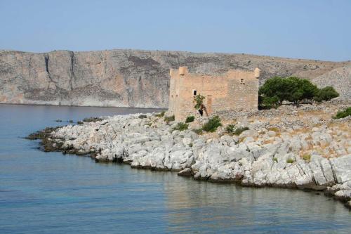 an old building on the side of a body of water at Akrotainaritis Rooms in Gerolimenas