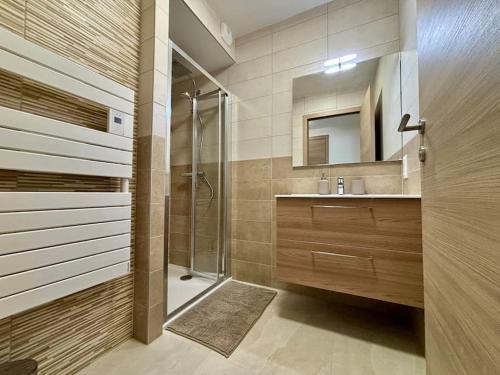een badkamer met douche, wastafel en spiegel bij Thélème A202 - T4 avec vue panoramique sur la station in Châtel